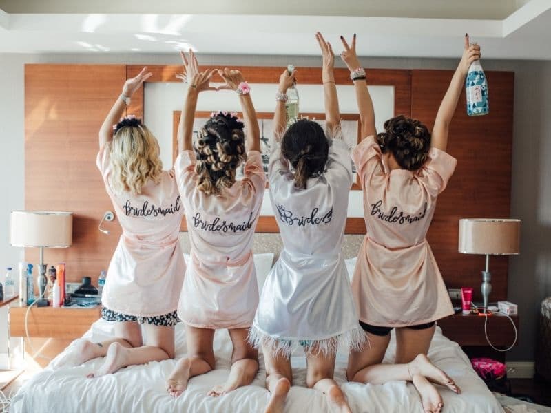 Filles portant des peignoirs satin brodés personnalisés pour un EVJF