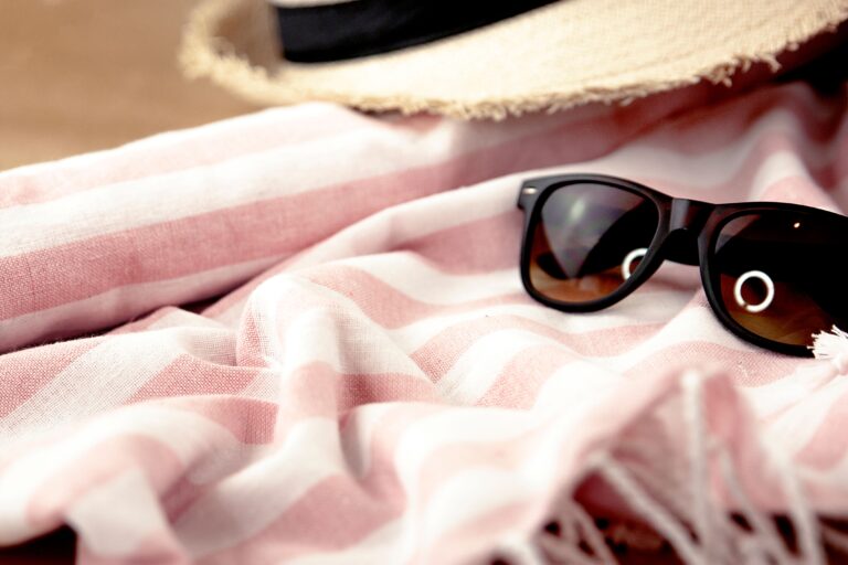 Fouta personnalisée brodée au prénom, posée sur un transat en bord de plage
