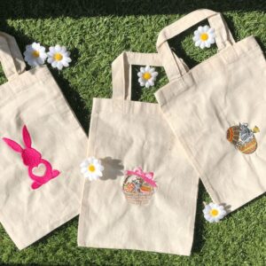 Trois tote bags en coton brodés de motifs de Pâques : lapin, panier d'œufs et œuf décoré