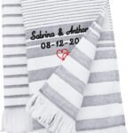 Fouta blanche et grise à rayures et à franges brodée de deux prénoms, d'une date et de deux cœurs rouges