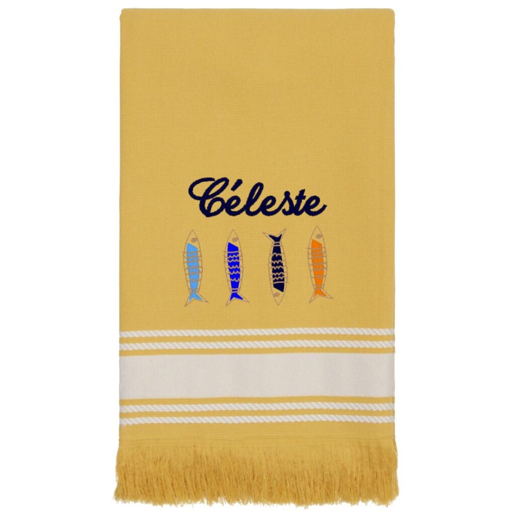 Fouta de plage jaune à franges brodée du prénom Céleste en bleu marine, avec un motif de quatre sardines colorées