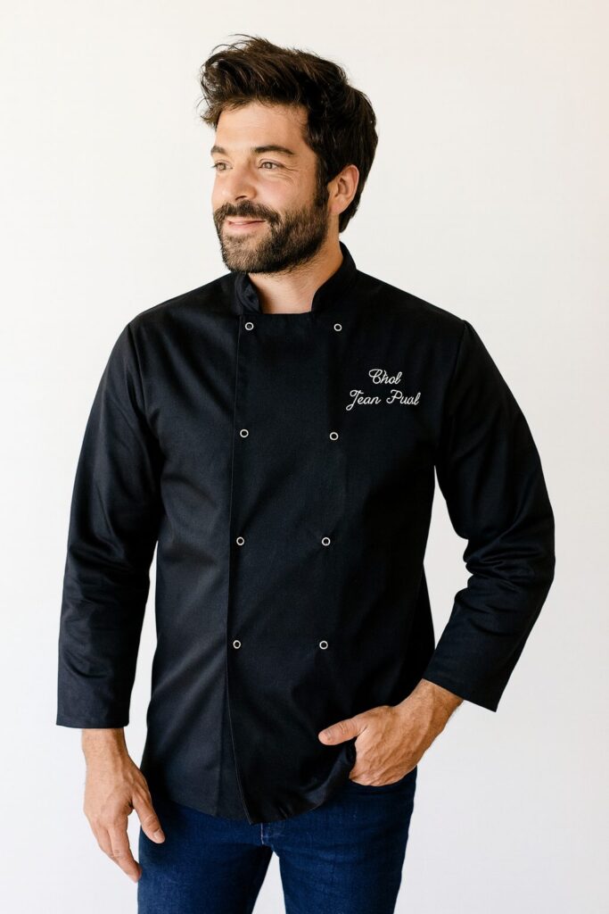Veste de cuisine noire brodée Chef Jean-Paul portée par un cuisinier